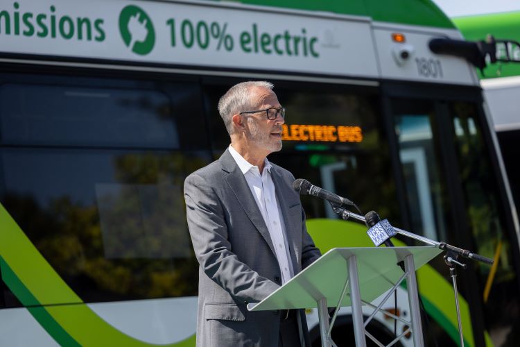 Congressman Jared Huffman makes an announcement in front of a green Marin Transit battery electric bus.